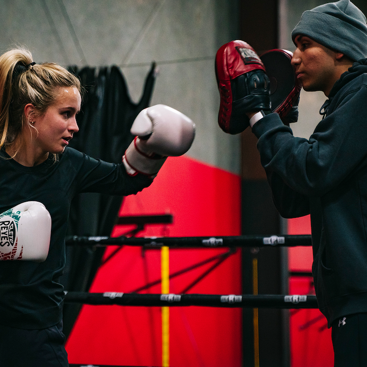 Woman mitt training with trainer at Nick's Fight club - Gym Memberships